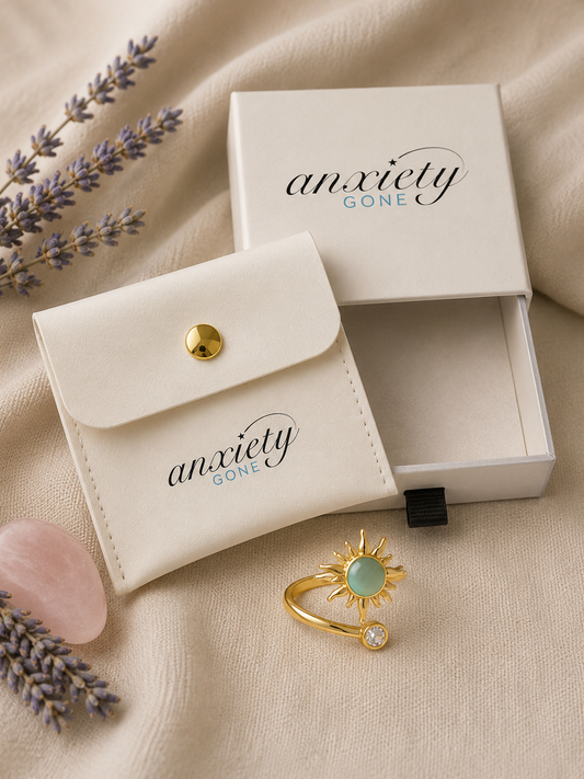 Gold sunburst anxiety ring resting on cream linen with dried lavender