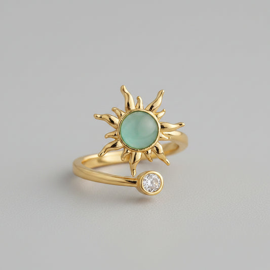 Adjustable fidget ring in gold with spinning sunburst and pale green center stone