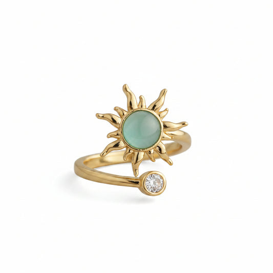 Adjustable fidget ring in gold with spinning sunburst and pale green center stone