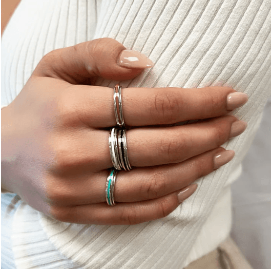 Sterling Silver Fidget Ring for kids and adults with enamel spinning bands in rose, turquoise, and white, displayed with complimentary MeditationRings Tin and Travel Pouch