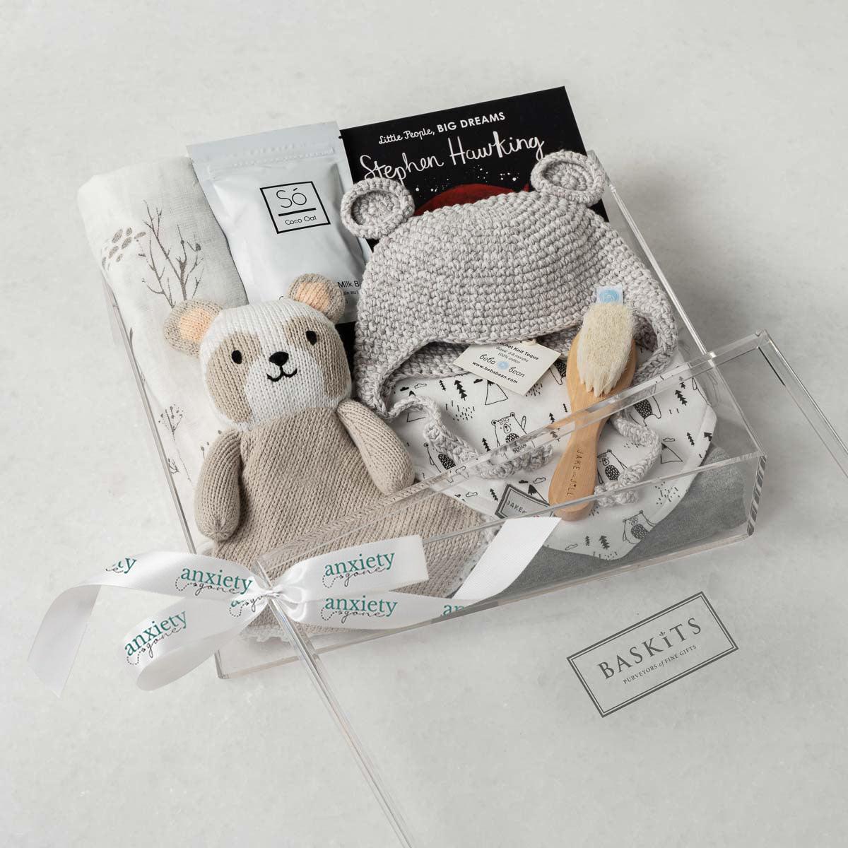 Baby Bear Gift Box – Premium new baby gift basket featuring a crochet knit toque with bear ears, cotton onesie, goat brush, forest-patterned swaddle, plush panda, coconut & oat milk bath, and classic "Brown Bear, Brown Bear" book. Ideal for baby showers, birthdays, or gender-neutral gifts for a newborn.