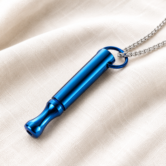 A metallic blue breathing tool pendant necklace with a silver chain, resting on a textured beige fabric background.