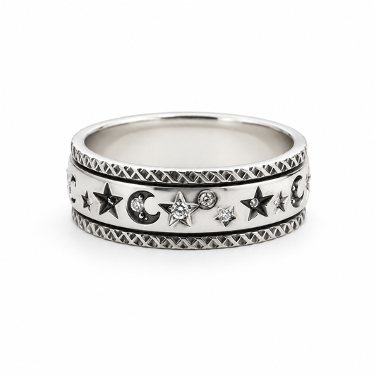 A silver celestial band  fidget ring featuring stars, crescent moons, and small clear gemstones, set against a plain white background.