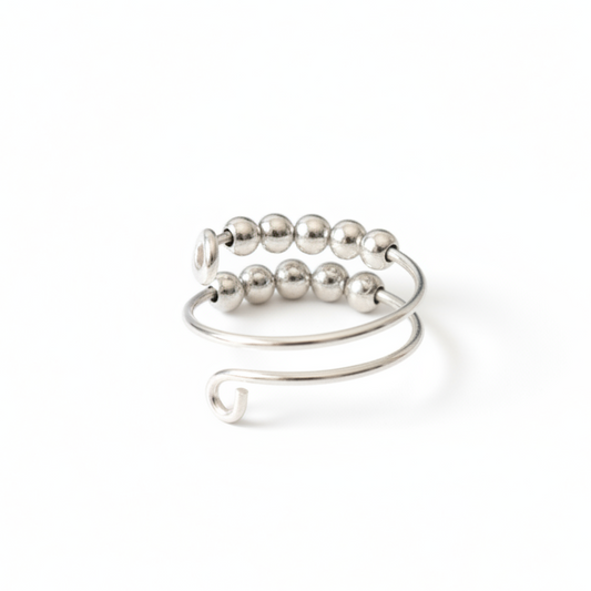 Silver fidget ring with beads on a light gray background
