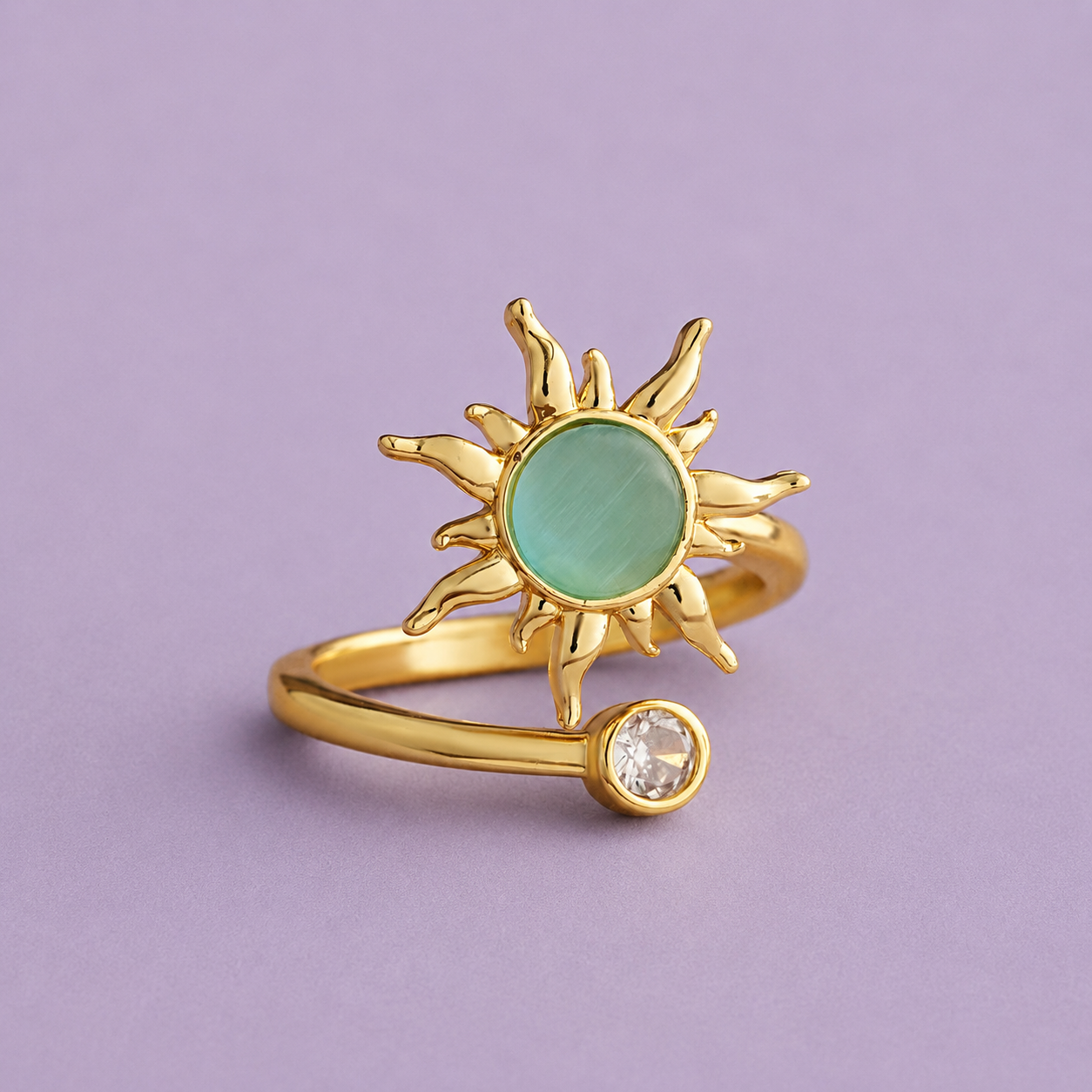 Gold sun spinner ring shown open band style with clear accent stone