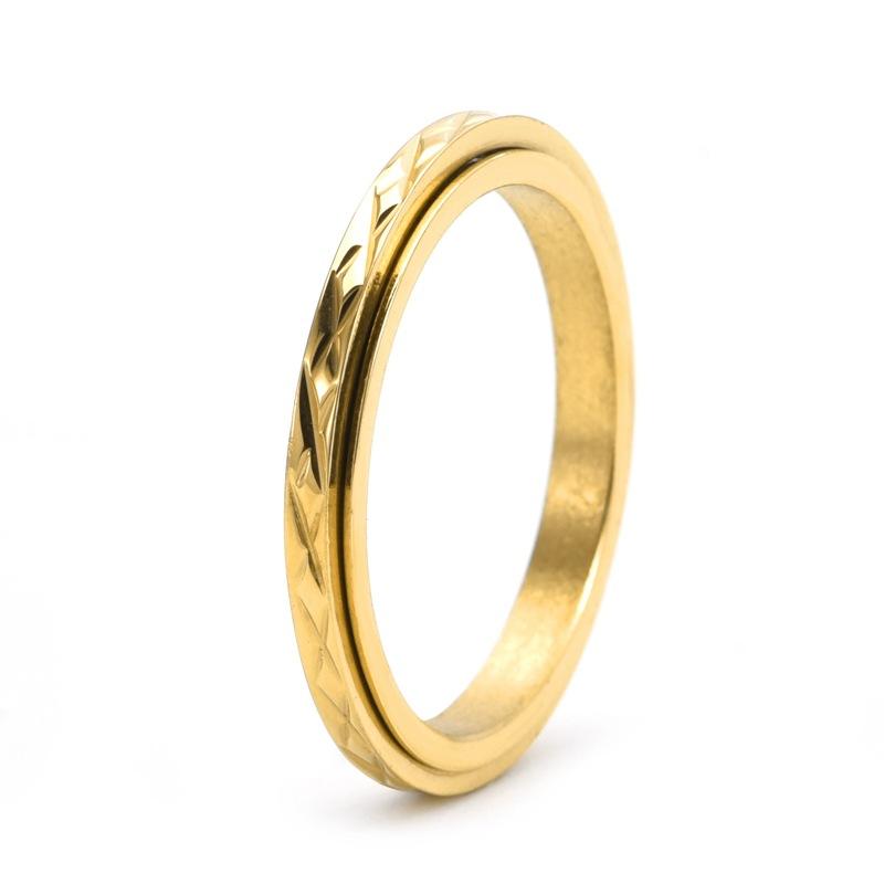 Dainty anxiety ring in gold with faceted spinning band on white background