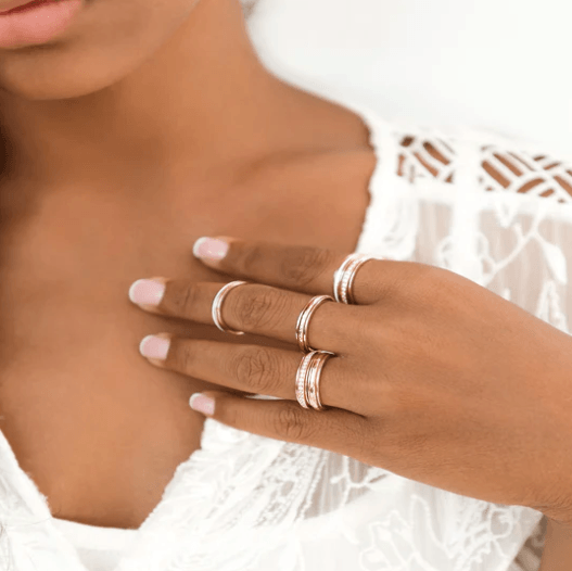 14 KT Rose Gold Fidget Ring with spinning band adorned with clear CZ stones, displayed with complimentary MeditationRings Tin and Travel Pouch