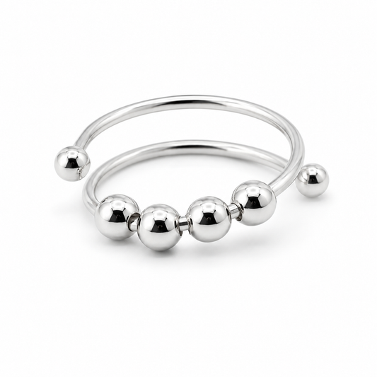 A polished silver-tone metal fidget ring with five evenly spaced spherical beads, shown on a clean white background.
